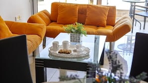 A modern living room with a sofa and a glass coffee table. - 1 Bedroom apartment located in the heart of protaras. (Protaras)