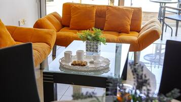 Una sala de estar moderna con un sofá y una mesa de centro de vidrio.