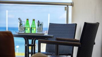 Un balcón con mesa y sillas, con vista al mar.