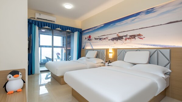 A hotel room with two beds, a large window with curtains, a wall mural, and a penguin decoration.