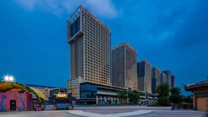 A modern urban area with high-rise buildings, a bus stop, and a pedestrian walkway. - Floral Hotel Frozen Adventure Guangzhou (Guangzhou)