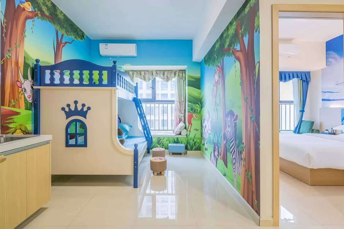 A child's bedroom with a bunk bed, a play area, and a mural of a forest scene.