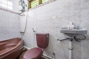 Een badkamer met een bad, toilet en wastafel.