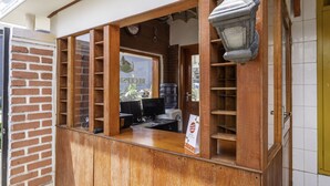 Un comptoir en bois, une pancarte, un distributeur d’eau et une horloge murale.