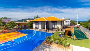 A residential property with a basketball court, a tent, and a house with a sloped roof. - Regina Ishigaki Kabira Sky (Ishigaki)
