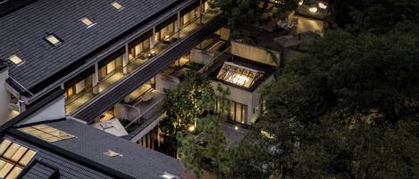 A multi-story building with a rooftop terrace and a lower level with outdoor seating.