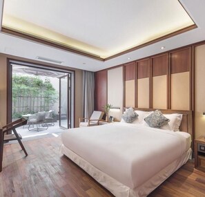 Ein modernes Hotelzimmer mit einem großen Bett, einem Schreibtisch und Blick ins Freie.