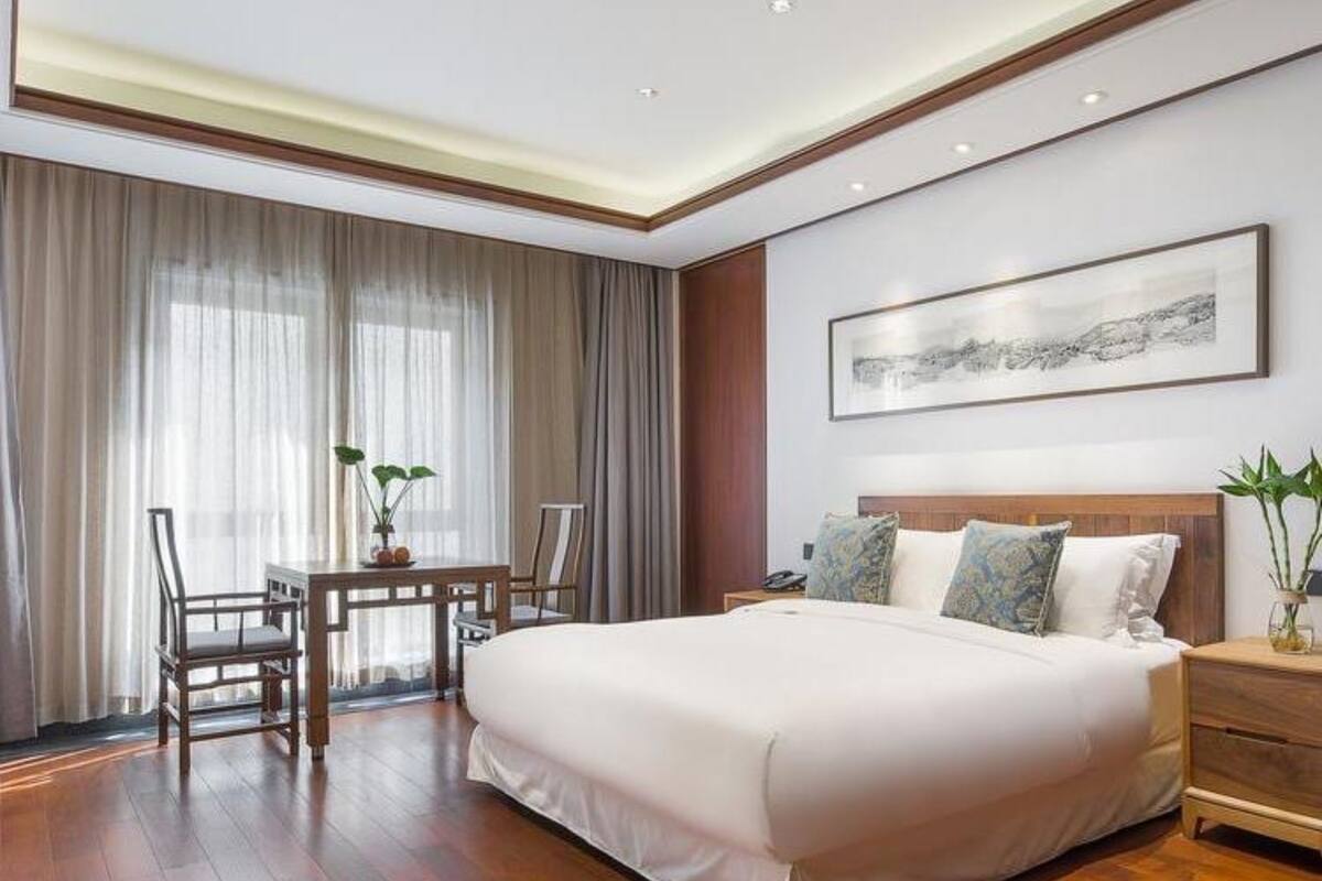 A spacious bedroom with a large bed, a desk, and a chair.