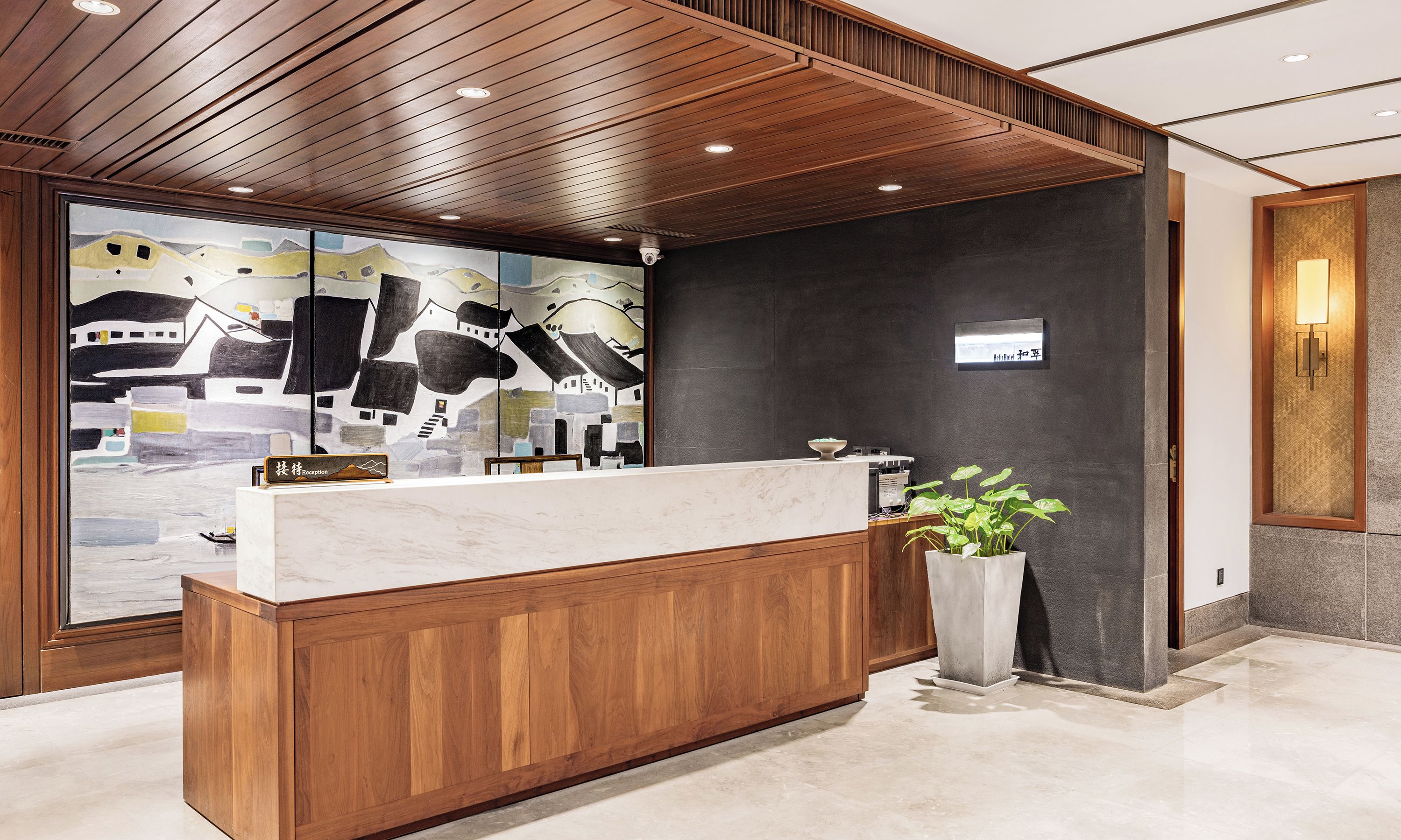 A reception desk with a wooden finish, a large window with a view of buildings, and a reception sign.