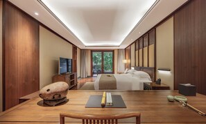 A hotel room with a bed, bedside table, TV, and a view of greenery outside. - Hefu Boutique Inn (Hangzhou)