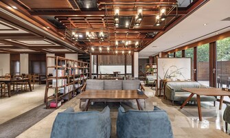 Un interior moderno con techo de madera, estanterías empotradas, una zona de estar central y un gran ventanal con vistas al exterior.