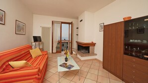 Una sala de estar con sofá, mesa de centro, chimenea y aparador.