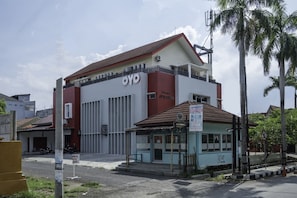 A building with a prominent 'OYO' sign, a small attached structure with a signboard, and a no parking sign. - OYO 2132 Pondok Avicenna (West Cirebon)