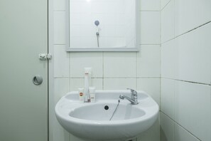 A bathroom with a white sink, a mirror, and a shower head. - OYO 2132 Pondok Avicenna (West Cirebon)
