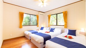 Habitación de hotel con dos camas, piso de madera y ventanas amplias con cortinas.