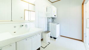 A modern bathroom with a large mirror, a white sink, and a shower area. - Regina Ishigaki Ocean Yonehara (Ishigaki)