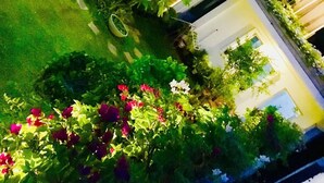 Un edificio de varios niveles con terrazas al aire libre, follaje y diversas plantas.