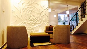 Una sala de estar moderna con un mural grande en la pared, una escalera y vistas al exterior.