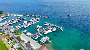 An aerial view of a marina with numerous boats docked, a pier extending into the water, and a clear sky. - Fedra: with lake view balcony naer to the lake (Manerba del Garda)