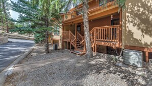 A two-story building with a wooden deck and stairs leading to the entrance. - Spacious Ruidoso Retreat w/ Hot Tub & 2 Kitchens! (Ruidoso)