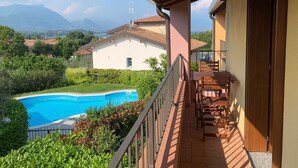 Un balcón con vistas a una piscina y montañas.