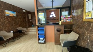 Un espace d’accueil comprenant un comptoir, des sièges et donnant sur l’extérieur.