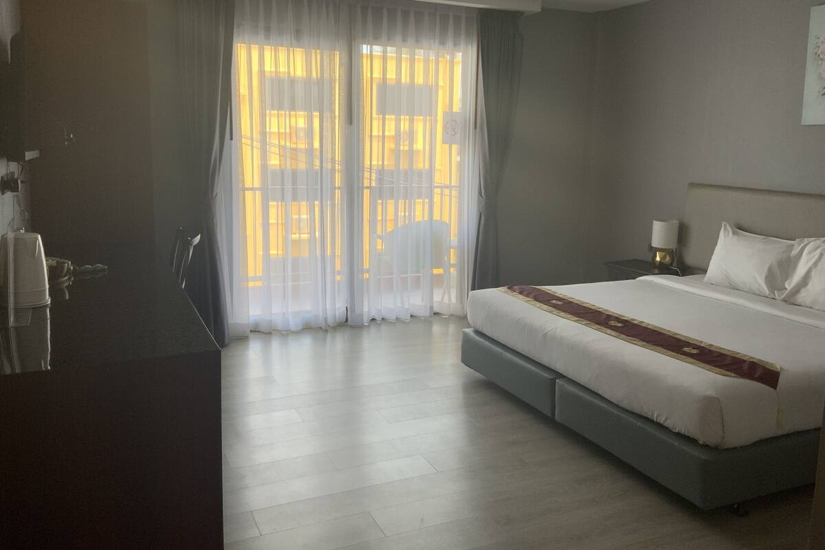 Een hotelkamer met een groot bed, een bureau en een stoel.