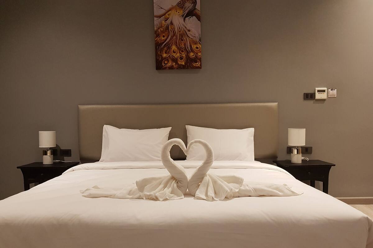 Een hotelkamer met een bed, twee nachtkastjes en een schilderij aan de muur.