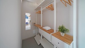A modern bathroom with white cabinets, wooden countertops, and a potted plant.