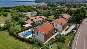 A residential area with houses, a swimming pool, and a view of the sea. - Gardaliva5: with lake view in new residence with pool near to the lake (Manerba del Garda)