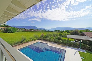 Ein Schwimmbecken mit Blick auf Berge und einen See.