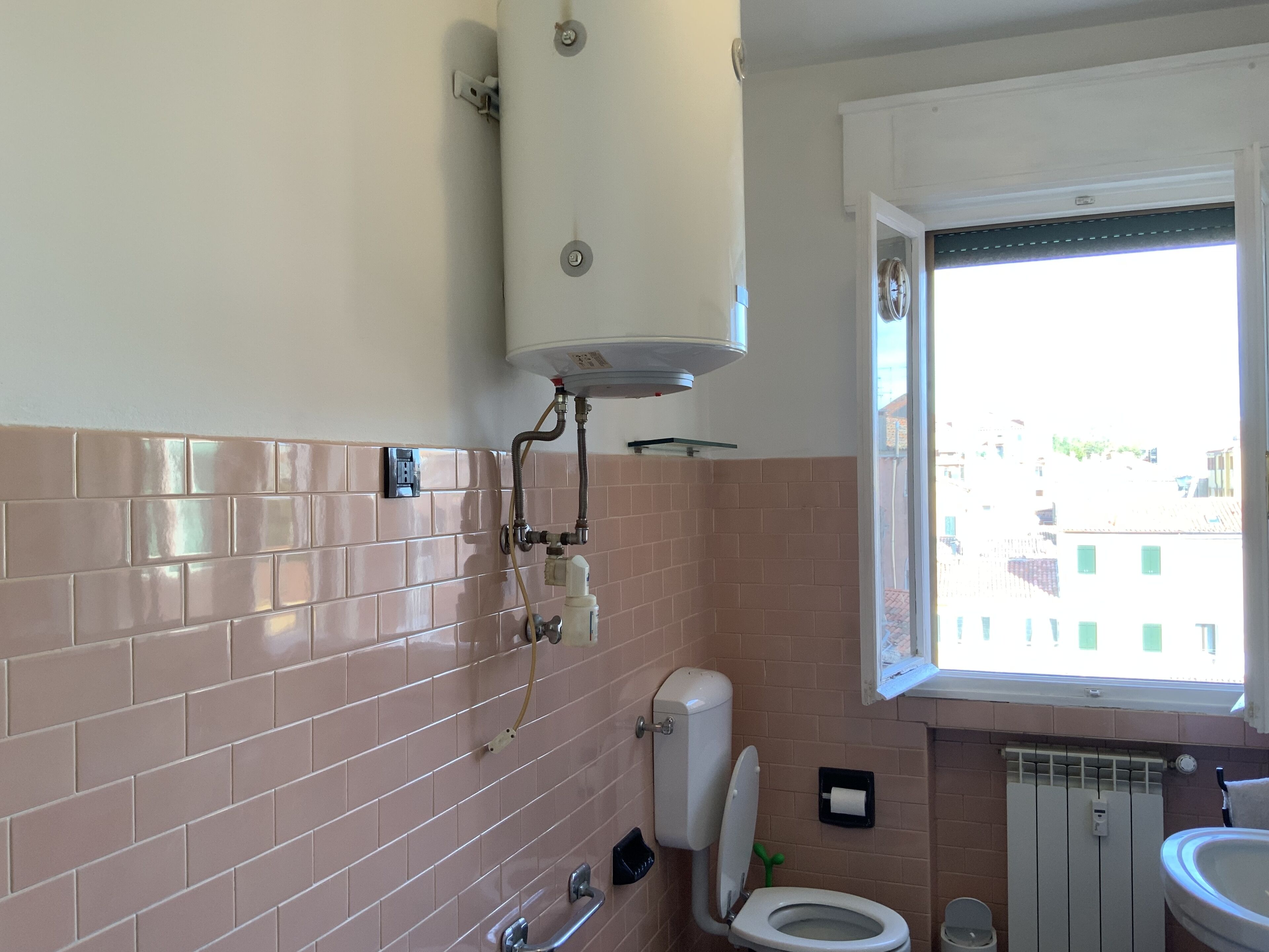 Un baño con inodoro, lavabo y ventana.
