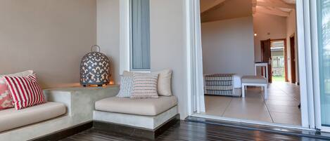 Um interior moderno com um sofá, um candeeiro estampado e um ventilador de teto.