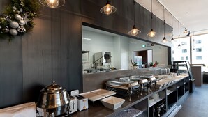 Um balcão de café da manhã moderno, com estações de comida estilo buffet, um espelho grande e um ramo decorativo de Natal.