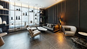 Uma sala de estar moderna com um sofá, poltronas, uma mesa de centro e uma estante.