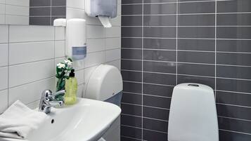 A modern bathroom with a white sink, a toilet, and a mirror.
