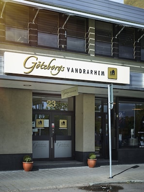 Welcome to Gotheborgs Vandrarhem, a charming hostel with a modern entrance featuring a double door and potted plants.