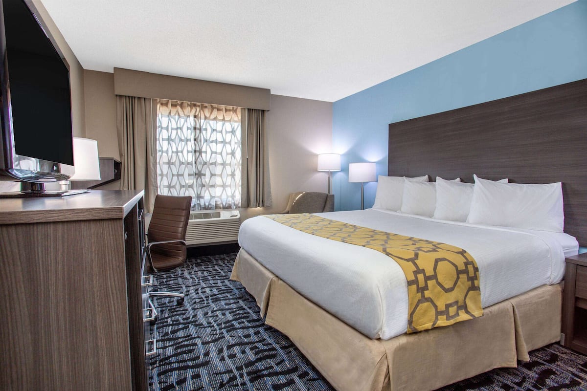 Une chambre d’hôtel équipée d’un lit, d’un bureau, d’une chaise et d’un téléviseur.