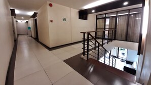 Un pasillo de hotel con una escalera que lleva a un balcón con vistas.