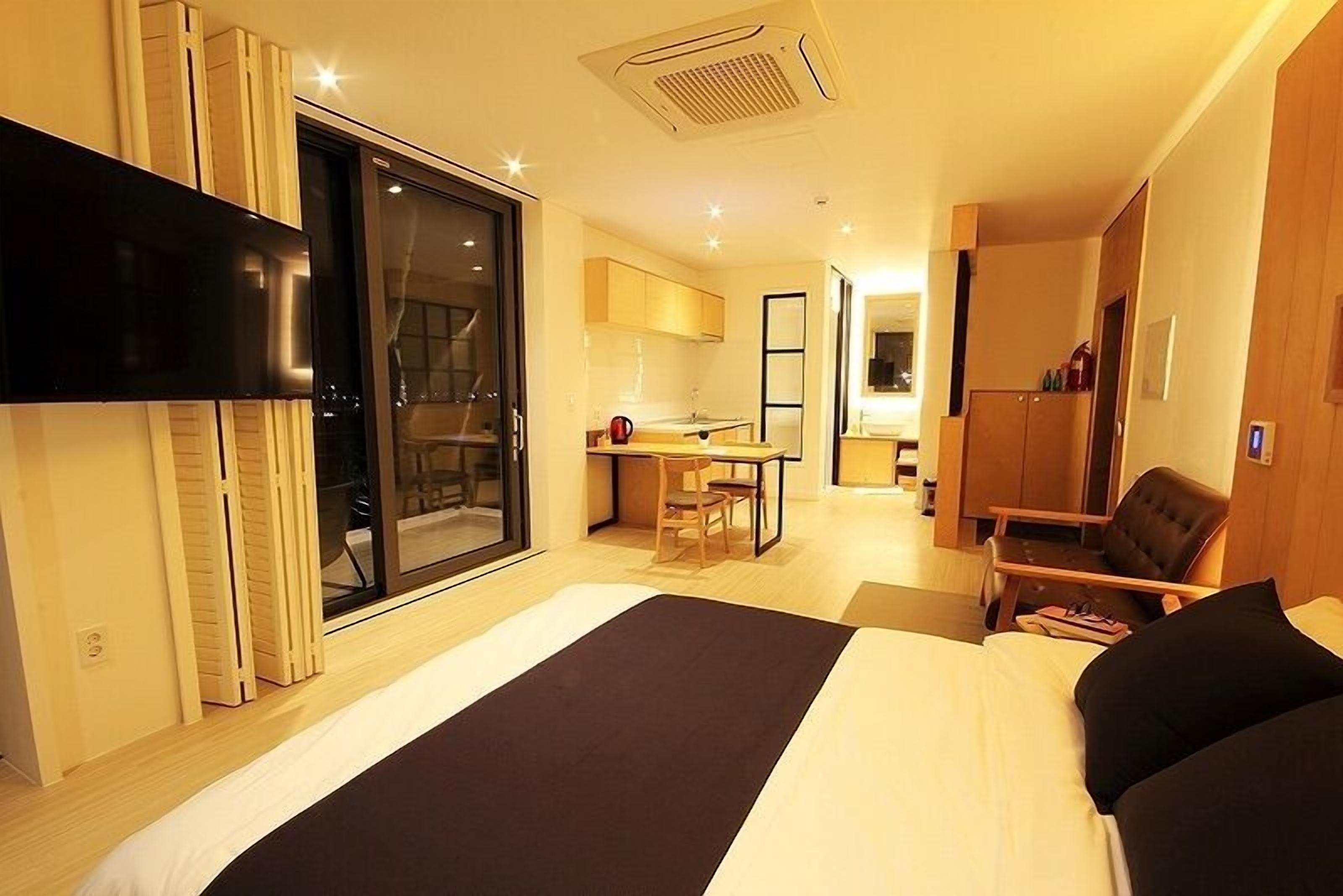 Una habitación de hotel moderna con una cama grande, un escritorio y un rincón de descanso.