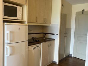 Kjøleskap, mikrobølgeovn, oppvaskmaskin og høy barnestol