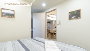 Ein Schlafzimmer mit einem Bett, einem Badezimmer und einer Essecke.