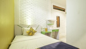 A hotel room with a bed, a desk, and a mirror. - SPOT ON 2080 Rumah Kita Residence (Tasikmalaya)