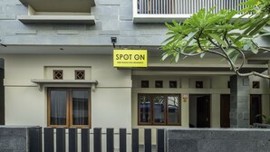 A building with a 'SPOT ON' sign, a balcony, and a door marked '49'. - SPOT ON 2080 Rumah Kita Residence (Tasikmalaya)