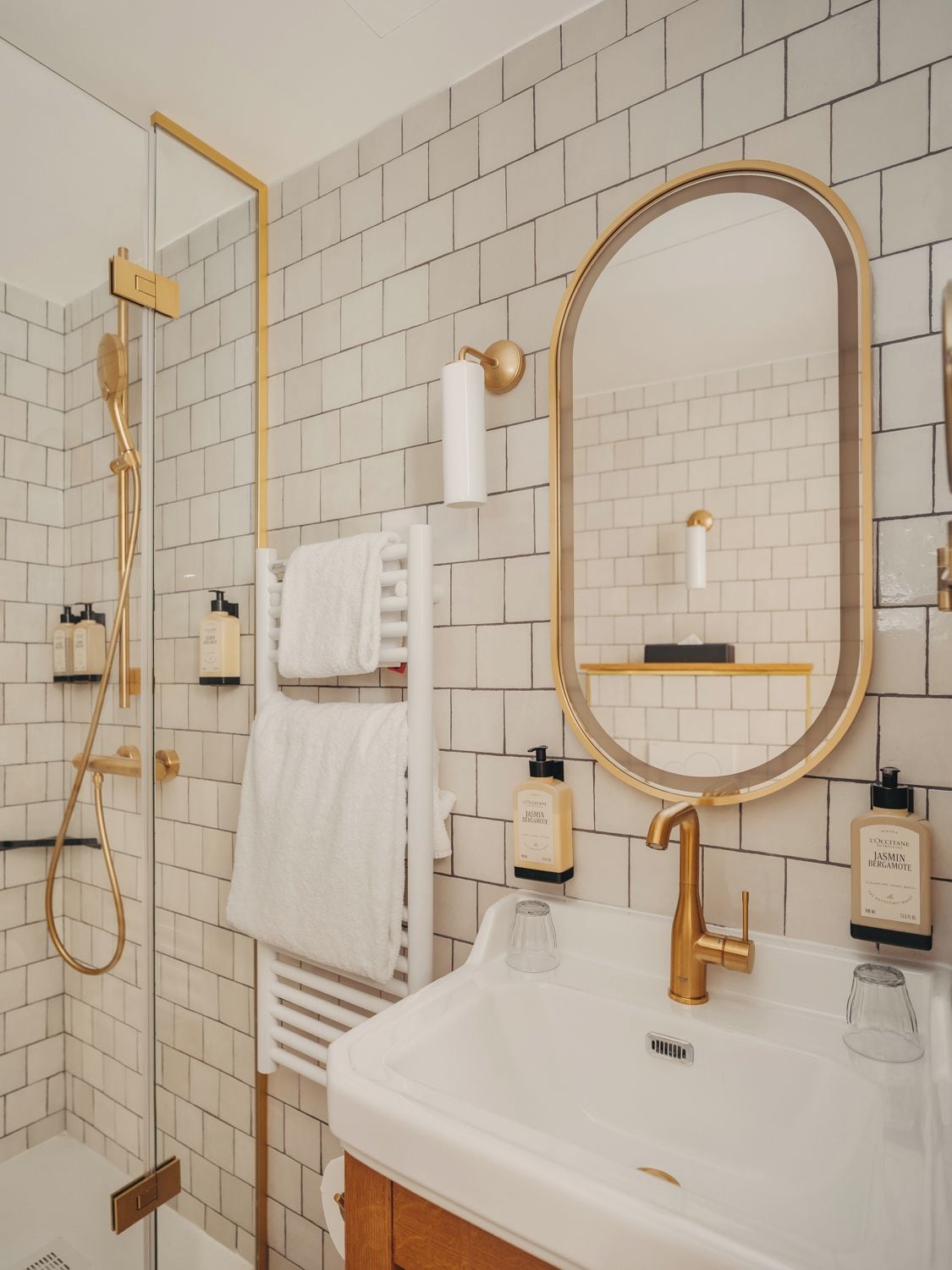 Un baño moderno con ducha, lavamanos y espejo.