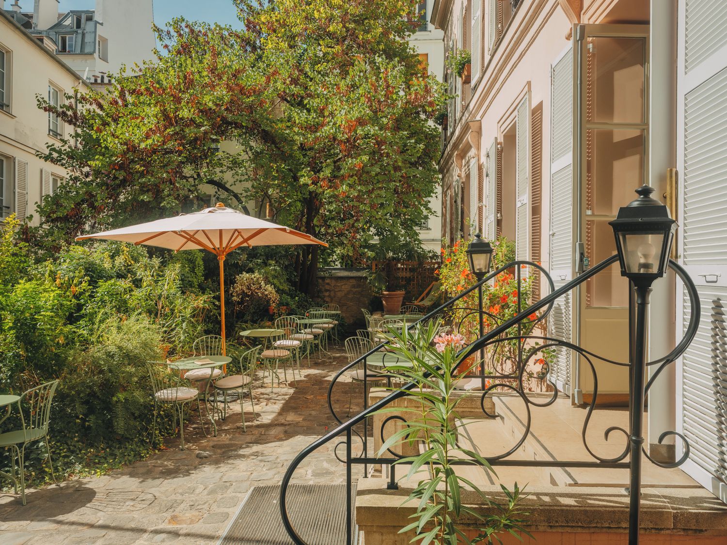 A courtyard with outdoor seating, a lamp post, and a staircase leading to an upper level.