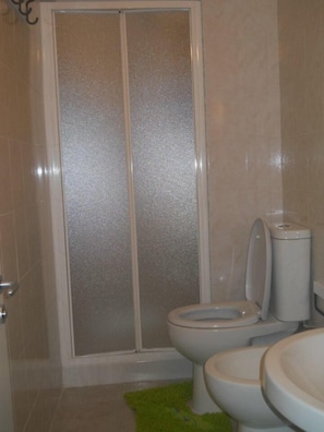 A bathroom with a shower enclosure, two toilets, and a sink. - Casa Maravigna (Catania)