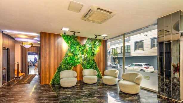 A lobby with a green wall, marble flooring, and four chairs. - Dem İstanbul Airport Hotel (Istanbul)