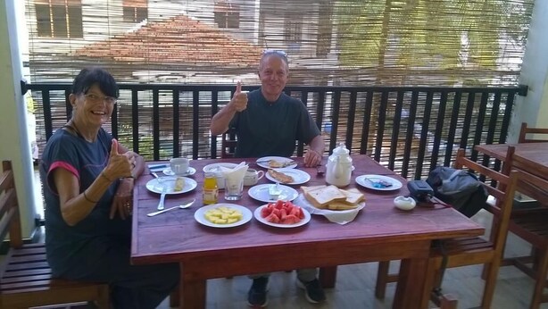 Una mesa de madera con platos de comida, una jarra y una taza.