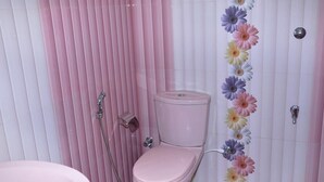 Un baño con inodoro rosa, ducha y lavabo.
